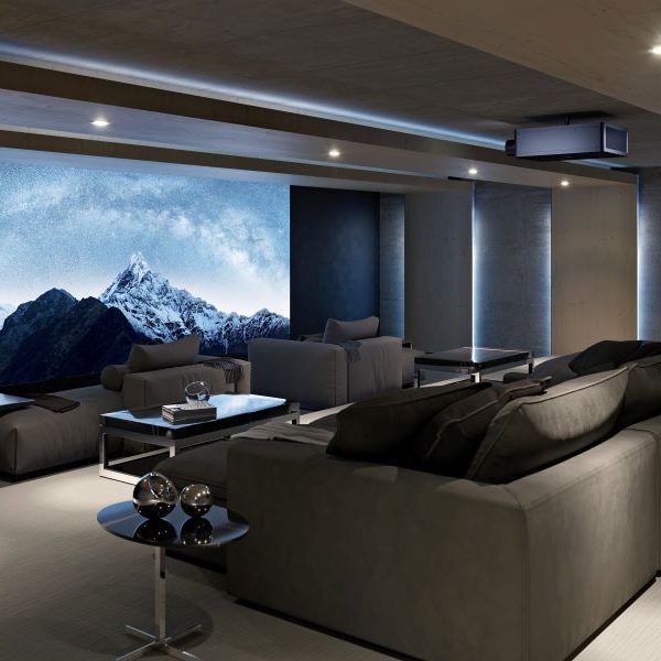 Discover-Ho-a-Home-Theater-Company-Brings-Your-Vision-to-Life A home theater with chaise lounges, a large screen depicting snow-capped mountains, and a Sony projector.
